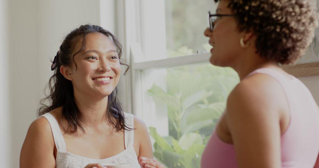 Duas mulheres conversam em ambiente acolhedor: apoiar quem vive o ciclo da violência começa por ouvir sem julgar.